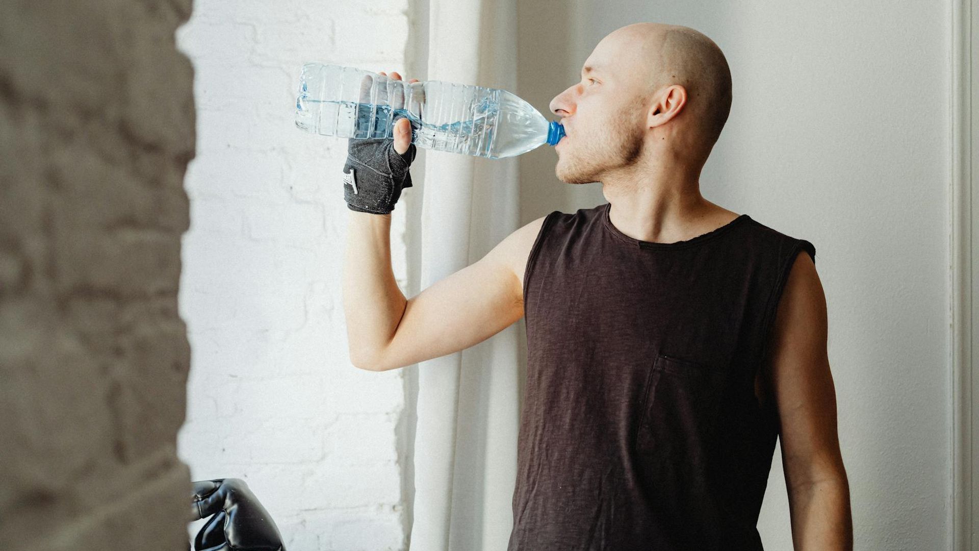 Man performing a controlled strength exercise in a minimalist gym setting.